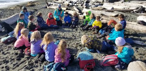 Students sitting in a circle at the beach